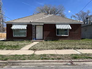 Bungalow-style home featuring brick siding and a tiled roof