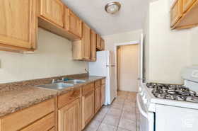 Kitchen with white appliances and light tile patterned floors