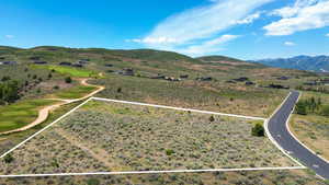 Aerial view of property and surrounding area featuring property boundaries highlighted and a mountain backdrop