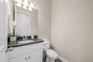 Half bathroom featuring vanity and toilet