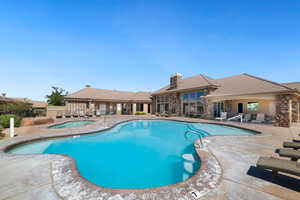Community pool with a patio area and a hot tub