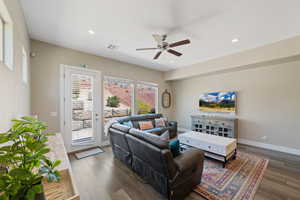 Living room with a ceiling fan, wood finished floors, and recessed lighting