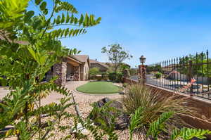 View of yard with an area to practice putting and a patio