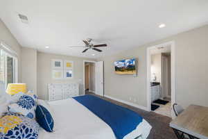 Bedroom with carpet floors, recessed lighting, a ceiling fan, and connected bathroom