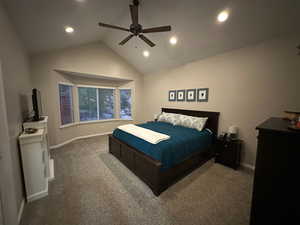 Primary bedroom featuring vaulted ceiling, bay window, and a ceiling fan