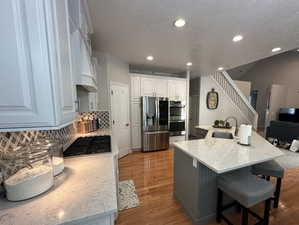 Kitchen with stainless steel appliances,  decorative backsplash and a spacious island