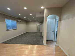 Carpeted family room with arched walkways and separate heat/ AC wall units