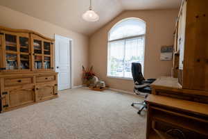 Carpeted office space with vaulted ceiling and baseboards