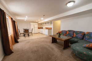Living room featuring bar area, light carpet, and recessed lighting
