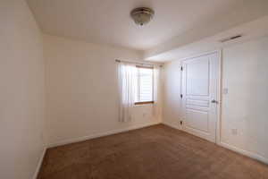 Carpeted empty room featuring baseboards