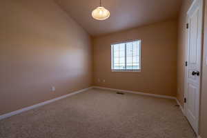 Unfurnished room with light carpet and lofted ceiling