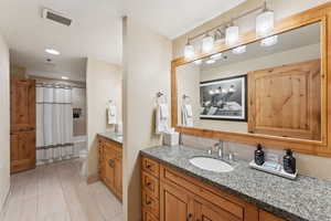 Full bath with vanity, shower / bath combo, and recessed lighting