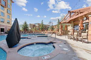 Community pool featuring a hot tub and a patio area