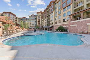 Community pool featuring a community hot tub and a patio