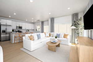 Living area with light wood finished floors, recessed lighting, and healthy amount of natural light
