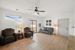 Living area with light wood style finished floors and ceiling fan