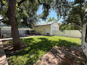 Fenced backyard featuring a covered patio shed, large detached garage and RV parking
