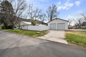 Large, detached garage with bathroom and workshop, RV parking and fully fenced corner lot with mature trees