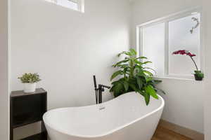 Full primary suite bath featuring a freestanding bath