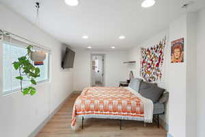 Primary bedroom with recessed lighting and light wood-style flooring