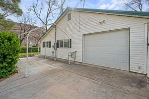 View of property exterior with attached garage and concrete driveway
