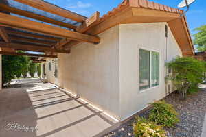 View of property exterior featuring stucco siding, a patio area, and a pergola