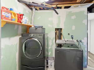 Laundry room featuring washing machine and dryer and wood finished floors
