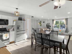 Dining space featuring light wood-type flooring, a chandelier, recessed lighting, and a ceiling fan