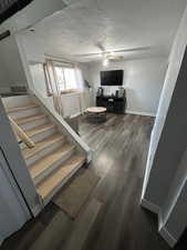 Staircase featuring a ceiling fan and wood finished floors