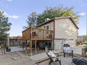 Back of property with a patio, a deck, stairs, a fenced backyard, and a gate