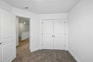 Unfurnished bedroom featuring carpet flooring and a closet