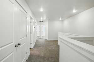 Corridor with carpet and recessed lighting