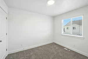 Unfurnished room with dark carpet and baseboards