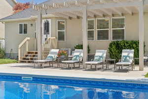 Outdoor pool with a pergola and a patio