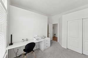 Office with light colored carpet and baseboards