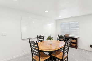 Dining space featuring light colored carpet and recessed lighting
