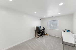 Office area with light carpet and recessed lighting