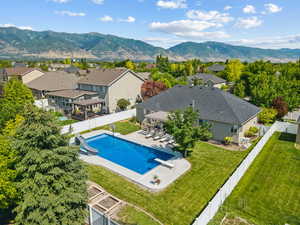 View of pool featuring a water slide, a fenced backyard, a patio area, and a mountain view