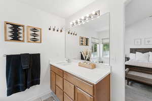 Ensuite bathroom with vanity and tile patterned flooring
