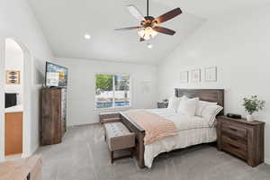Bedroom featuring light carpet, arched walkways, ceiling fan, high vaulted ceiling, and recessed lighting