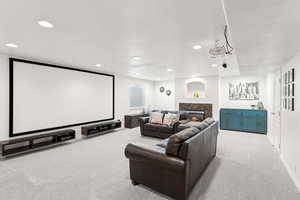 Cinema room with light carpet, recessed lighting, and a fireplace
