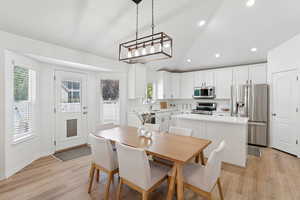 Dining space with light wood-style floors, plenty of natural light, and recessed lighting