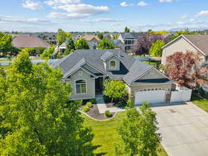 Traditional-style home featuring a shingled roof, a garage, a residential view, and driveway
