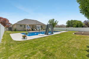 View of swimming pool with a shed, a fenced backyard, a patio, and a water slide