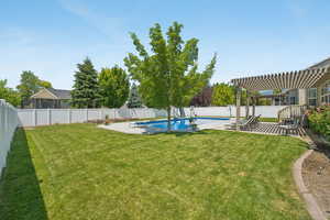 Fenced backyard with a pergola and a patio