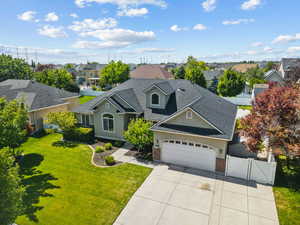 View of front of property with a gate, a residential view, brick siding, concrete driveway, and an attached garage