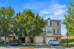View of front of home with driveway, a garage, and a front lawn