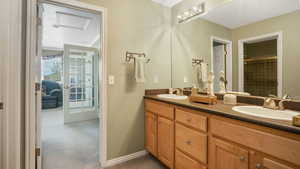 Full bath featuring double vanity and tiled shower