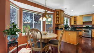 Dining area featuring a chandelier, dark wood-style flooring, recessed lighting, and crown molding