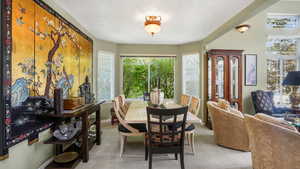 Dining space featuring baseboards and light carpet